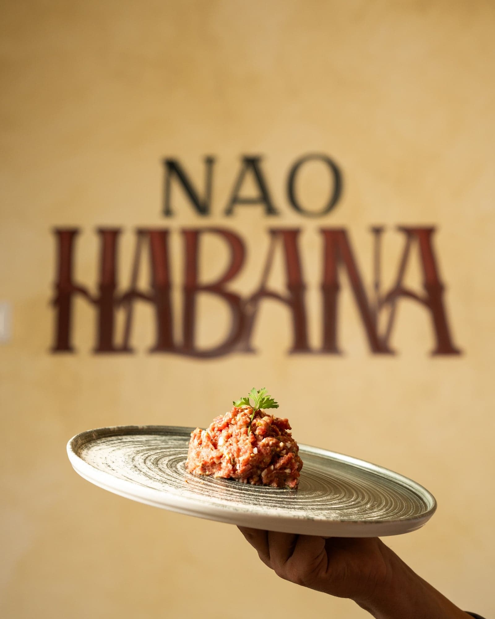 Steak tartar servido frente al mural NAO Habana